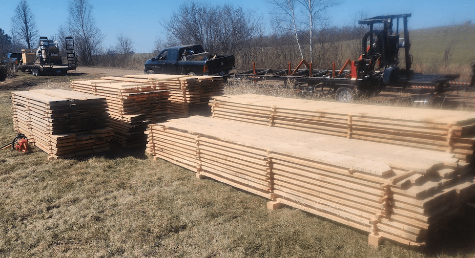 Fresh-sawn lumber stacked with TimberKing sawmill